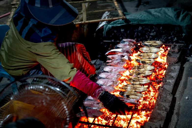 a person that is cooking some food on a grill, by Julia Pishtar, pexels contest winner, process art, fish seafood markets, vietnam, warm coloured, rectangle