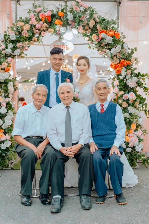 a group of people sitting next to each other, a colorized photo, by Tan Ting-pho, pexels contest winner, portrait photo of an old man, wedding, looking confident, ruan jia and brom