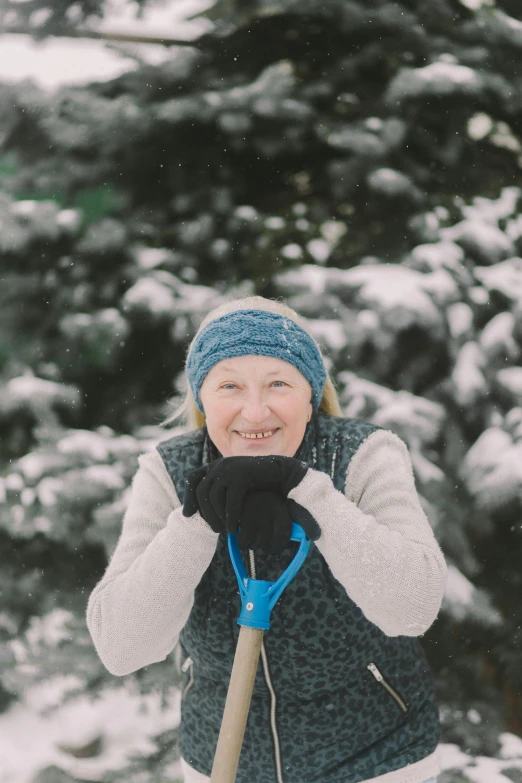 a woman standing in the snow holding a snow shovel, inspired by Louisa Matthíasdóttir, pexels contest winner, headshot profile picture, grandma, happily smiling at the camera, gardening