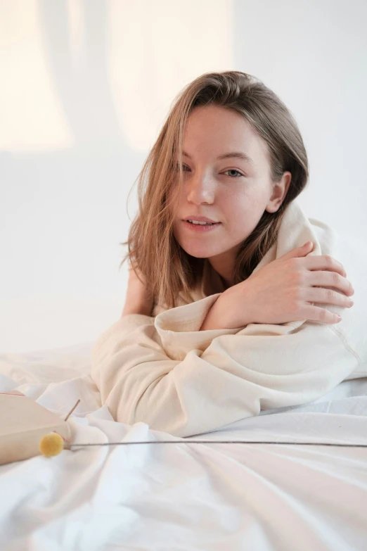 a beautiful young woman laying on top of a bed, by Alice Mason, trending on unsplash, happening, wearing nanotech honeycomb robe, sydney sweeney, portrait sophie mudd, on a white table