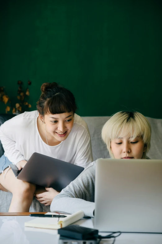 a couple of people sitting on a bed with a laptop, ayami kojima and lyde caldwell, on a couch, ui and ux, asian women