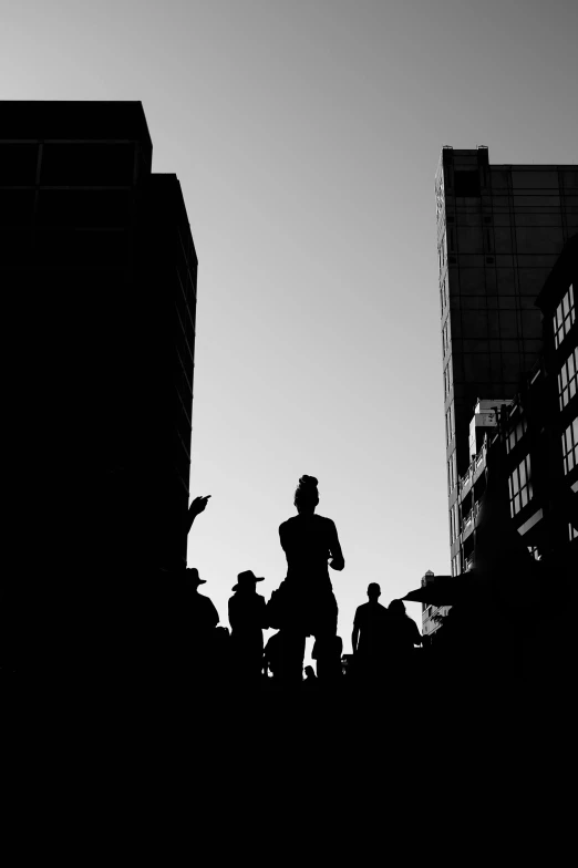 a black and white photo of a person on a skateboard, a black and white photo, unsplash contest winner, crowded silhouettes, three people running a marathon, in the middle of new york, sun down