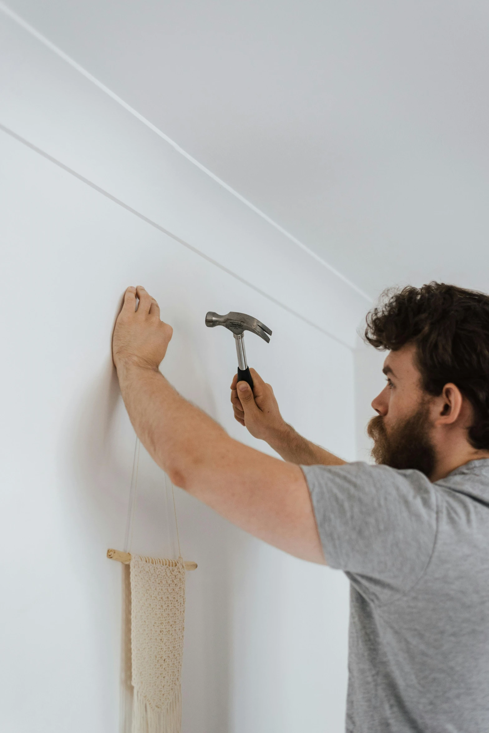 a man working on a wall with a hammer, profile image, manly design, white wall complex, matt finish