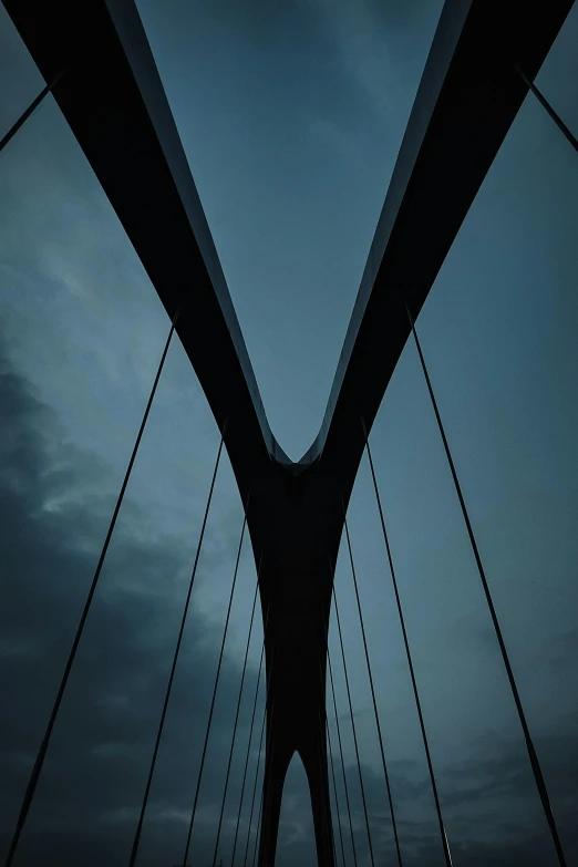 a black and white photo of a bridge at night, an album cover, by Jacob Toorenvliet, unsplash, postminimalism, blue sky, hanging veins, perfectly symmetrical, cables