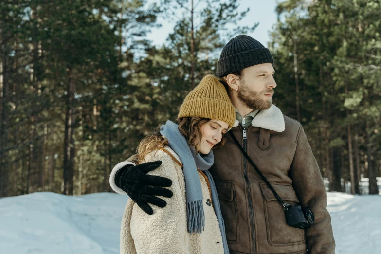 a man and a woman standing in the snow, inspired by Eero Järnefelt, pexels contest winner, wearing wool hat, film movie still, brown, jovana rikalo