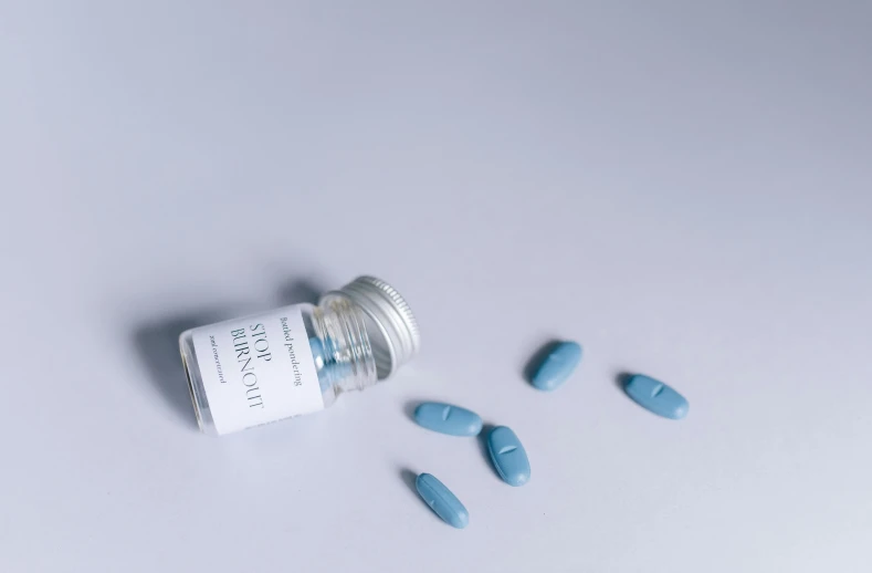 pills spilling out of a bottle on a white surface, by Sebastian Vrancx, unsplash, bauhaus, with blue skin, transgender, hibernation capsule close-up, still in package