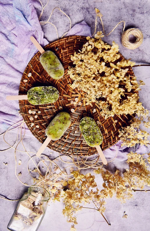 a close up of a plate of food on a table, dried flowers, lollipops, green tones, product display photograph