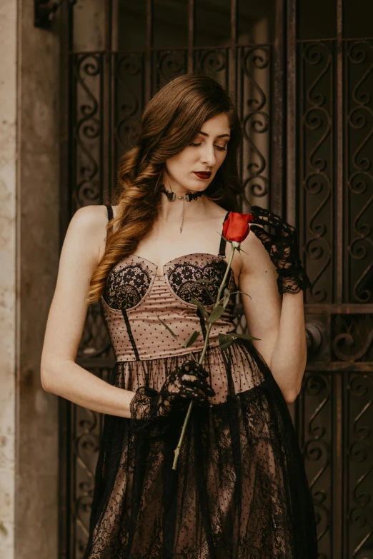 a woman in a black dress holding a rose, inspired by Elsa Bleda, trending on pexels, renaissance, wearing corset, balcony, sheer, velvet with lace gown