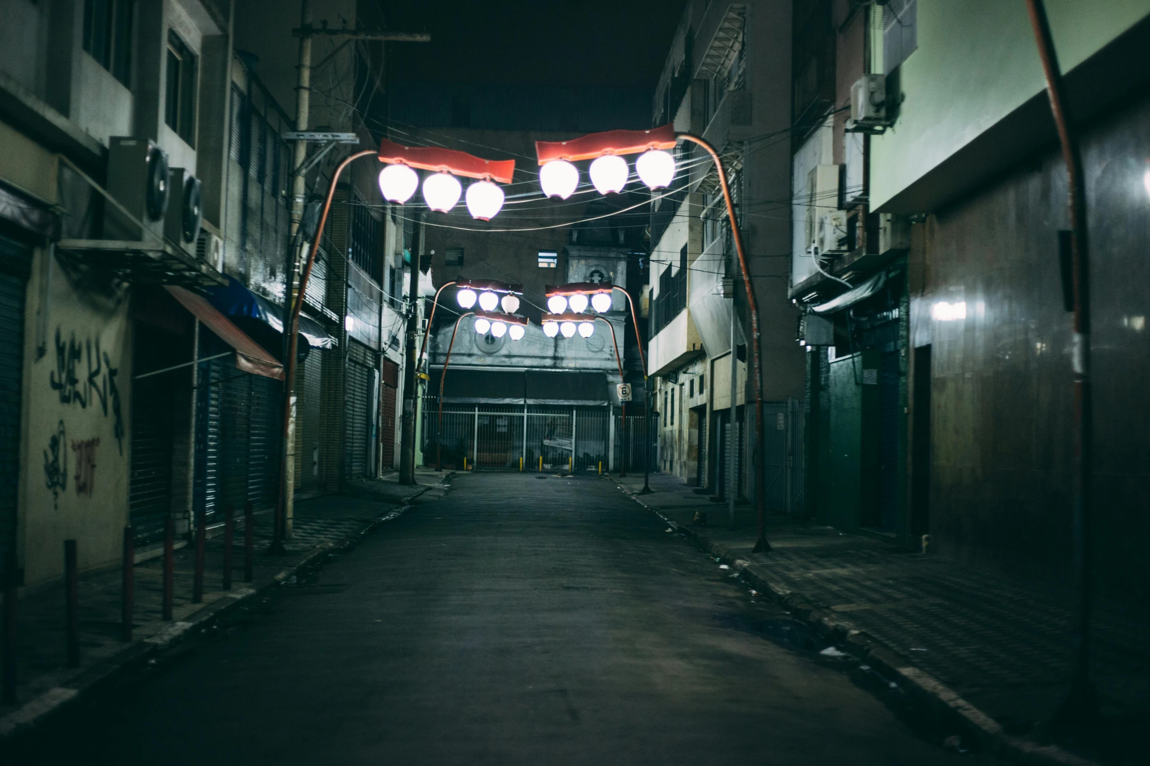 a street filled with lots of lights next to tall buildings, unsplash contest winner, mingei, deserted shinjuku junk town, horror setting, inside of a tokyo garage, evil spirits roam with lanterns