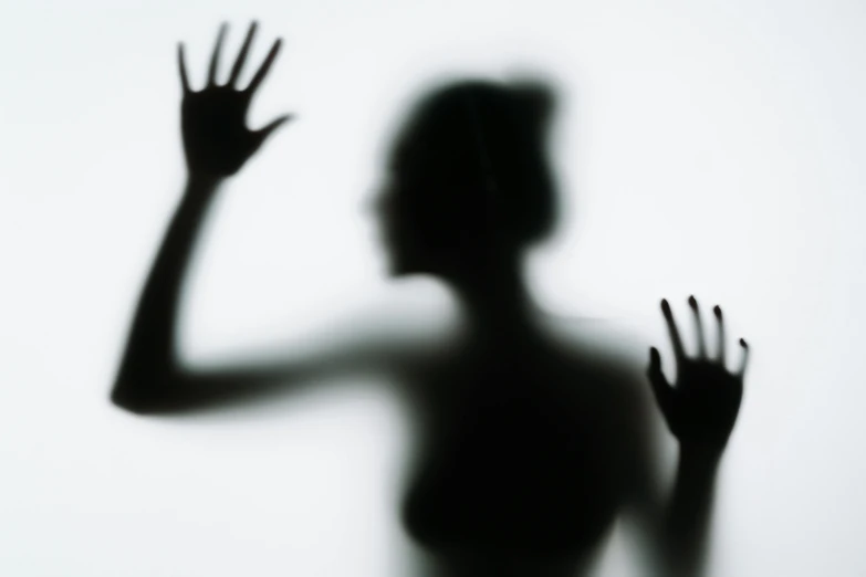 a silhouette of a woman with her hands in the air, an album cover, inspired by Lillian Bassman, pexels, figurative art, disfigured figure, transparent glass woman, ghostly figures, blurred