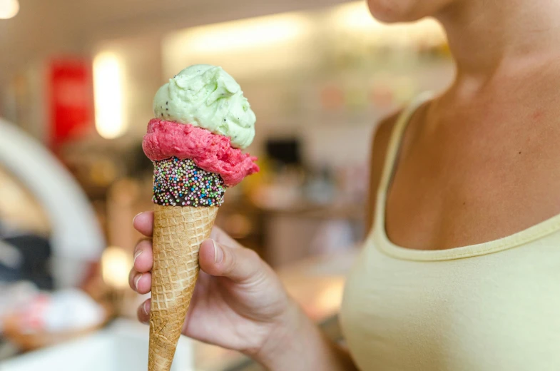 a woman holding an ice cream cone with sprinkles, a photo, by Dan Content, trending on pexels, renaissance, green and pink, epicurious, a small, sydney hanson