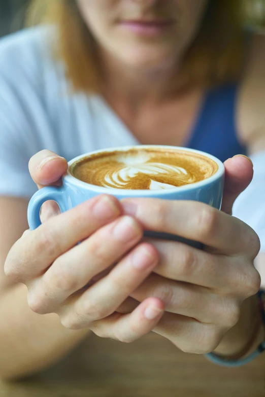 a close up of a person holding a cup of coffee, blue, aussie baristas, mesmerising, single pair of hands