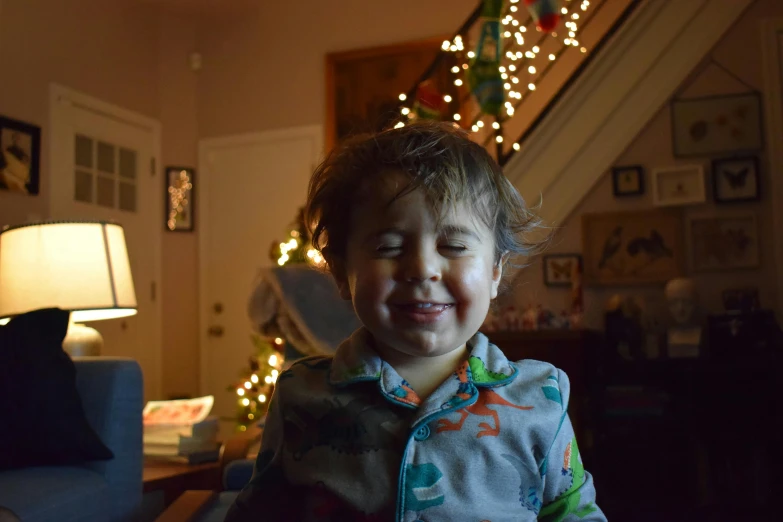 a little boy sitting on a couch in front of a christmas tree, a portrait, by Carey Morris, reddit, crying and smiling franticly, avatar image, good lighted photo, profile image