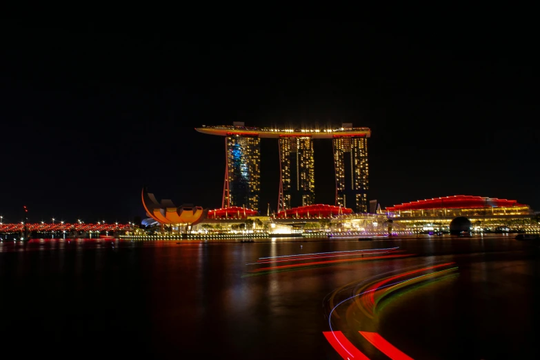 a long exposure photo of a city at night, by Patrick Ching, pexels contest winner, singapore esplanade, fan favorite, orange and red lighting, medium format