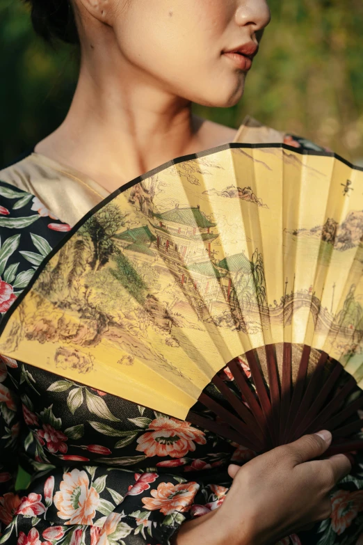 a woman in a kimono is holding a fan, inspired by Fan Qi, unsplash, renaissance, summer setting, made of silk paper, yellow, historical photo