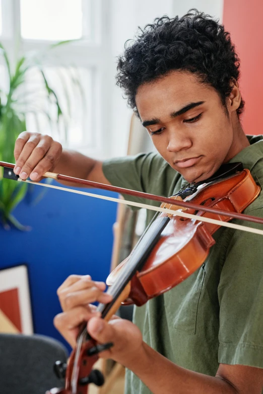 a young man playing a violin in a living room, pexels contest winner, black teenage boy, headshot, thumbnail, pulling strings