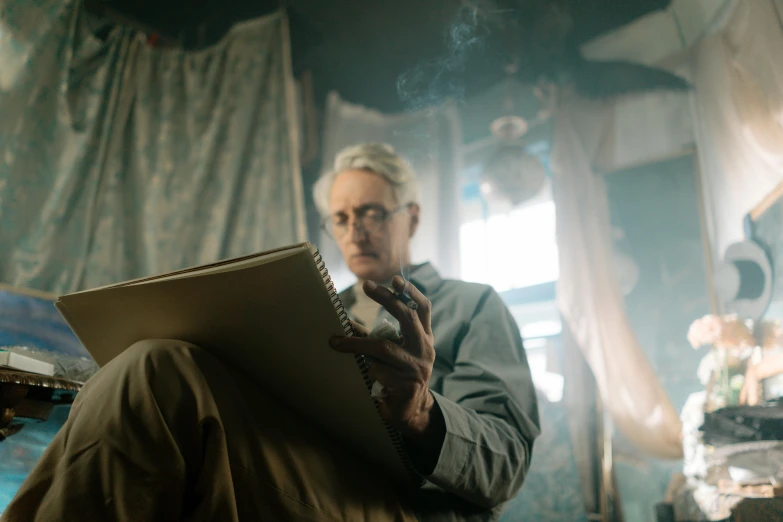 a man sitting on a bed reading a book, a portrait, by David Begbie, pexels contest winner, with smoke, in roger deakins style, holding notebook, dementia