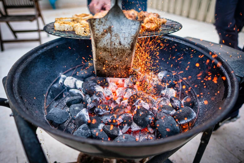 a close up of a person cooking food on a grill, rocks and metal, bowl filled with food, striking colour, crackling black lightning