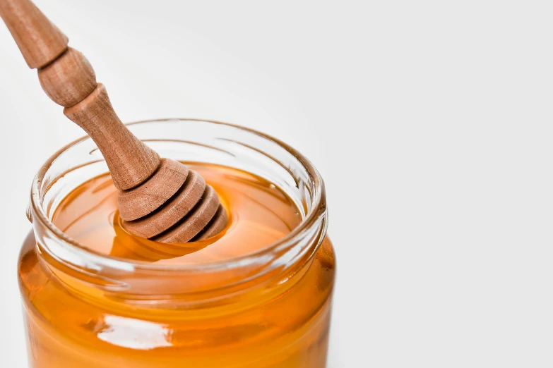 a jar of honey with a wooden spoon sticking out of it, trending on pexels, hurufiyya, banner, 🦩🪐🐞👩🏻🦳, detailed product image, recognizable