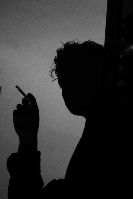 a man smoking a cigarette in a dark room, a black and white photo, outlined silhouettes, hziulquoigmnzhah, ((portrait)), aesthetics