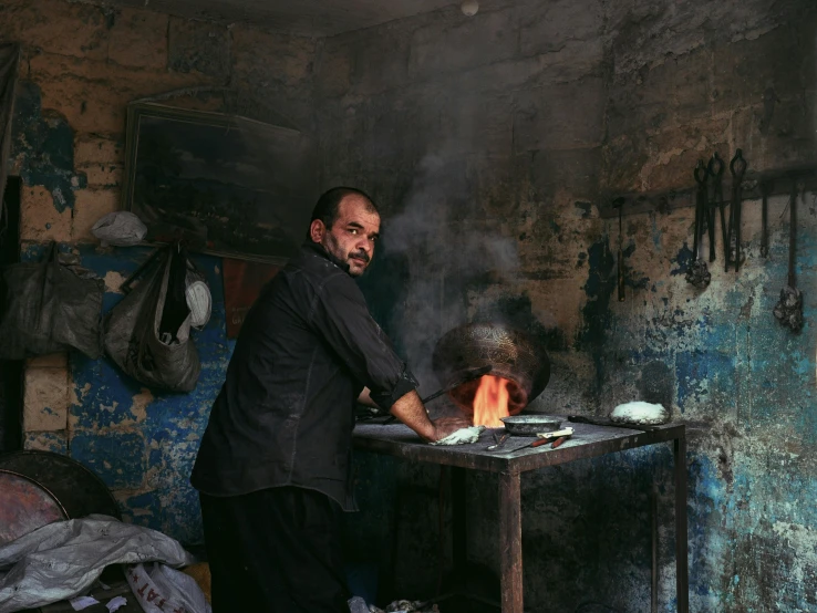 a man that is standing in front of a fire, les nabis, cooking, real life photo of a syrian man, small manufacture, 2022 photograph