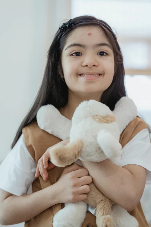 a little girl holding a teddy bear in her arms, inspired by Maurice Sendak, pexels contest winner, hurufiyya, south east asian with round face, playmates toys, rabbit, smiling