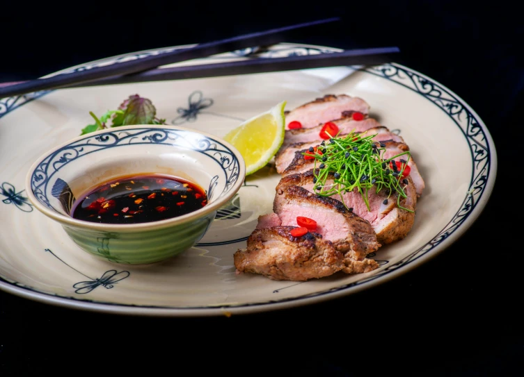 a white plate topped with meat next to a bowl of sauce, by Alice Mason, unsplash, shin hanga, hoang long ly, classic kabuki, duck, filleting technique