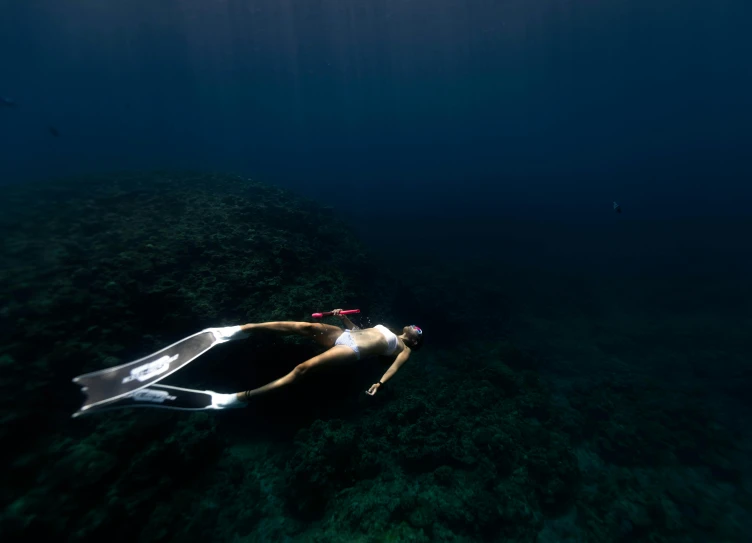 a person swimming in a body of water, deep ocean, lying down, azores, standing under the sea