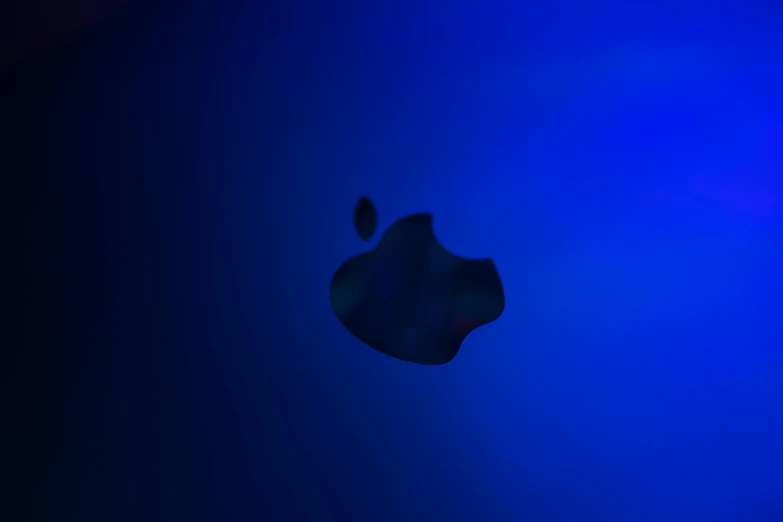 a close up of an apple logo on a blue background, a raytraced image, by Ryan Pancoast, unsplash, digital art, side profile in underwater, 8 k. volumetric lighting. dark, dark blue and black, instagram picture
