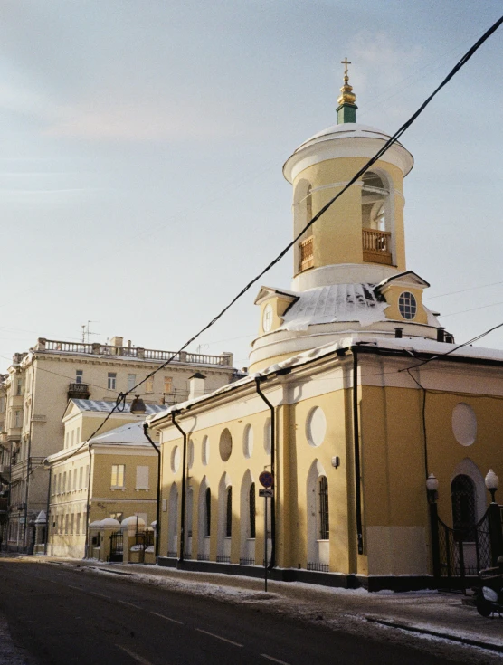 a large yellow building sitting on the side of a road, inspired by Illarion Pryanishnikov, renaissance, white church background, fujicolor sample, evening light, city views