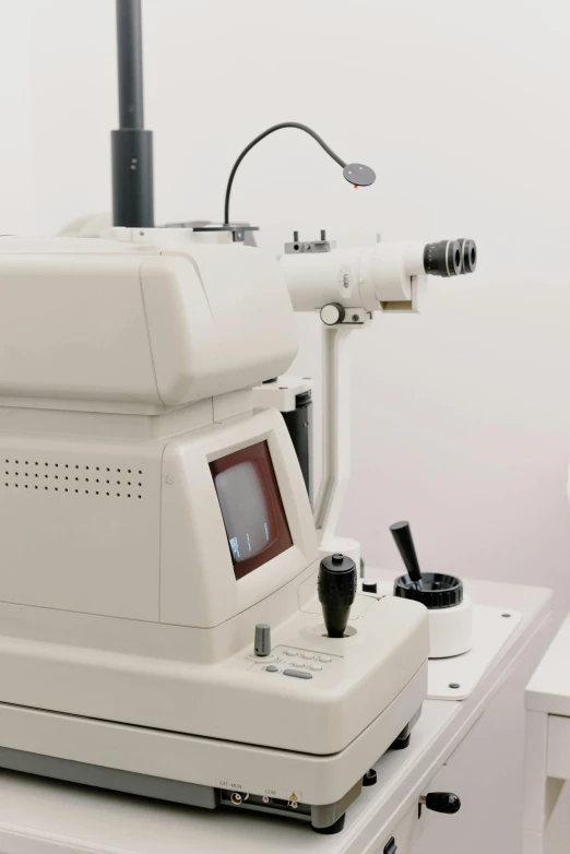 a machine that is sitting on top of a table, shutterstock, photorealism, black spot over left eye, diagnostics, 1990s photograph, white