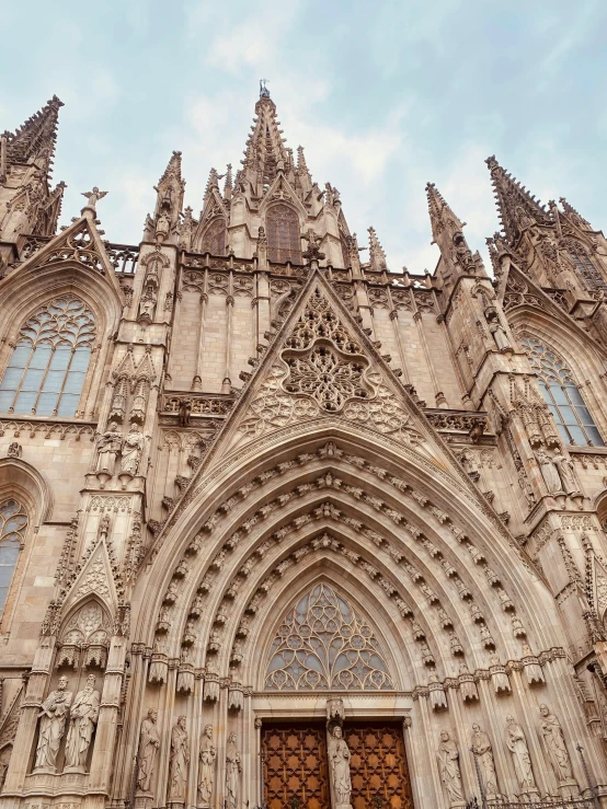 a group of people standing in front of a cathedral, inspired by Modest Urgell, pexels contest winner, highly detailed stonework, flying buttresses, seen from afar, front face