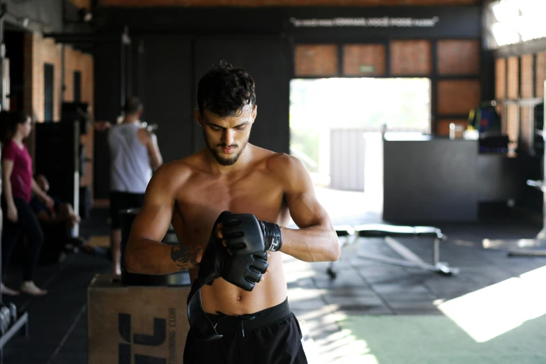 a shirtless man holding a pair of boxing gloves, by Daniel Lieske, pexels contest winner, local gym, avatar image, manuka, instagram picture