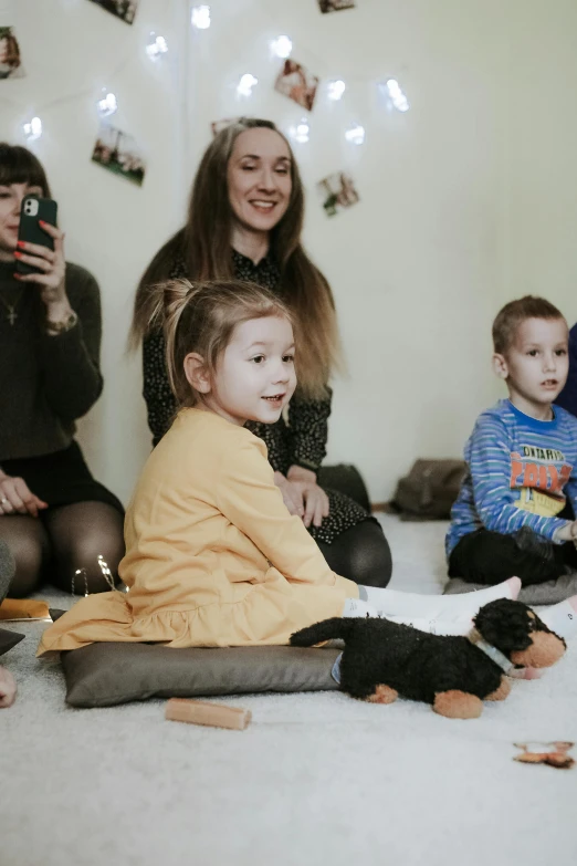 a group of people that are sitting on the floor, a child's drawing, anna nikonova, at a birthday party, high-quality photo, the woman holds more toys