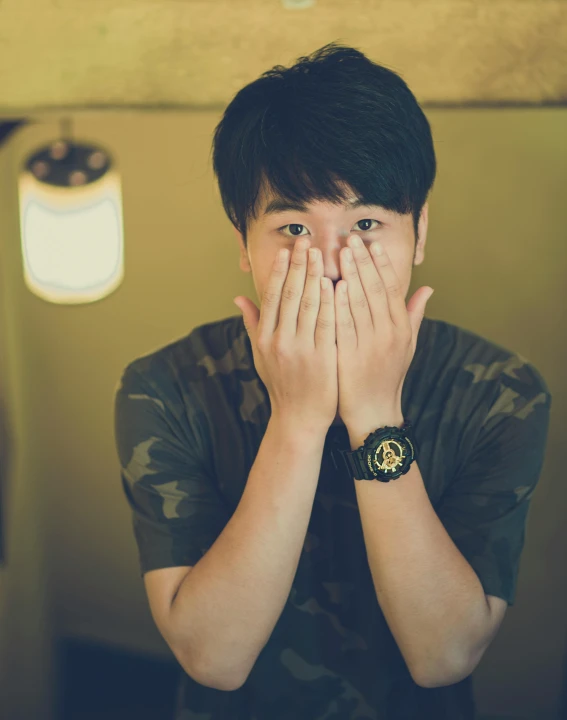 a young man covers his face with his hands, inspired by Yu Zhiding, pexels contest winner, wan adorable korean face, lgbtq, skeptical expression, taken in the late 2010s