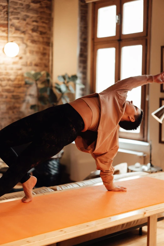 a man doing a handstand in a living room, by Matija Jama, pexels contest winner, sacral chakra, in a jumping float pose, dabbing, working out