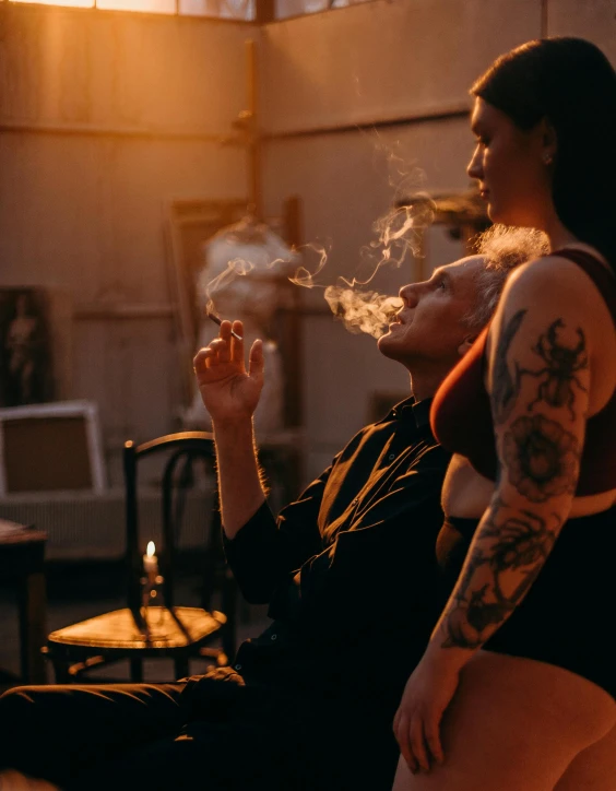 a woman sitting in a chair smoking a cigarette, trending on unsplash, two buddies sitting in a room, tattooed, profile image, lit up
