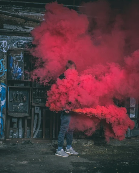 a man standing in front of a building covered in red smoke, pexels contest winner, graffiti, desaturated colours, made of cotton candy, ( ( ( colorful ) ) ), red and grey only