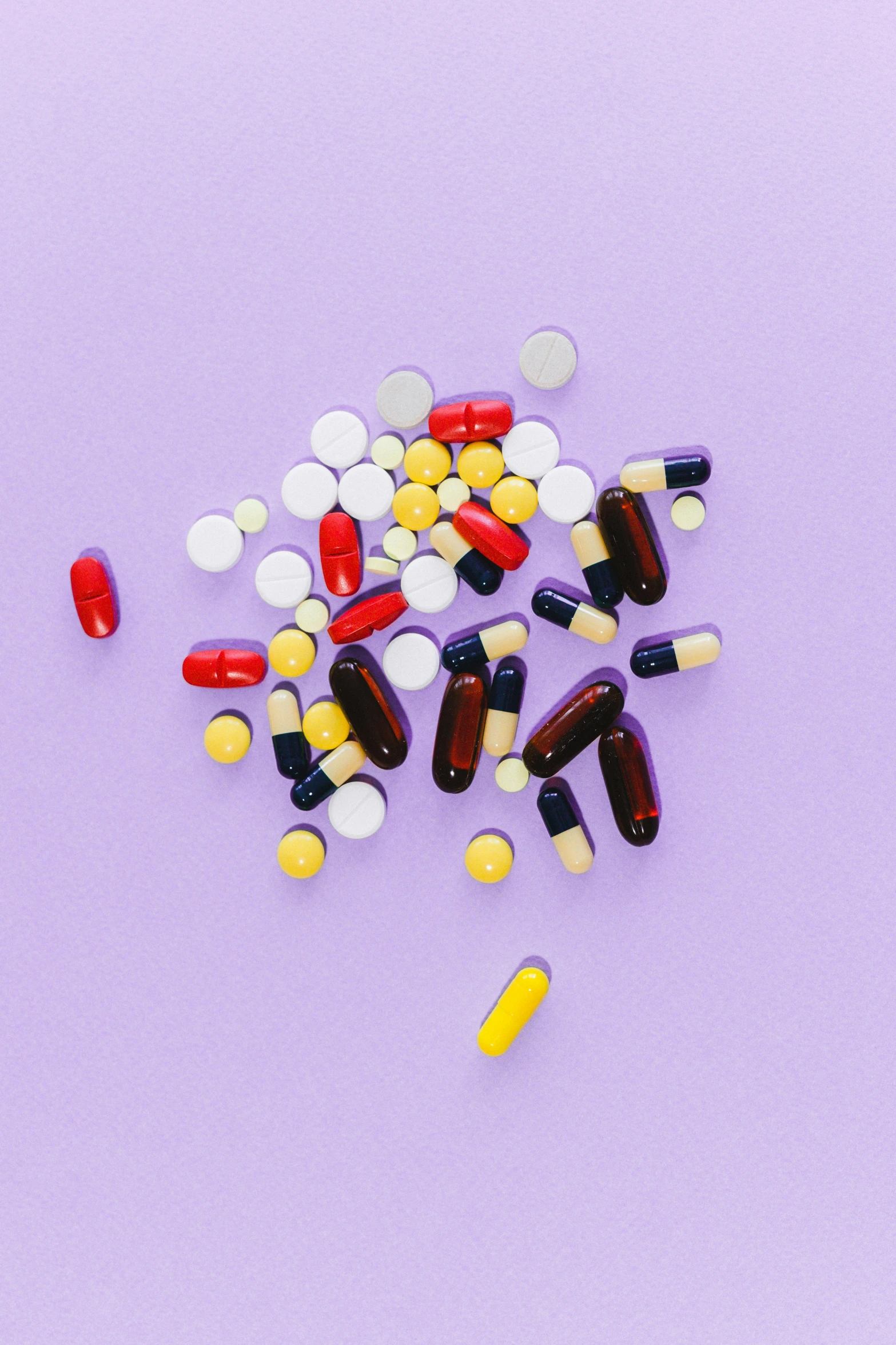 a pile of pills and capsules on a purple background, by Nicolette Macnamara, antipodeans, on grey background, some red and purple and yellow, medium-shot, multiple stories