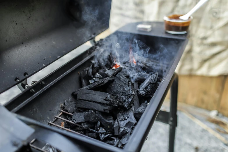 a charcoal grill with smoke coming out of it, by Joe Bowler, pexels contest winner, black vertical slatted timber, ash ketchup, detail shot, slate