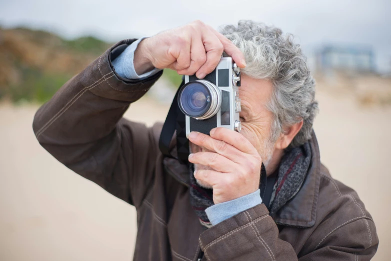 a man taking a picture with a camera, by Peter Churcher, 5 0 mm photograph, on the beach, medium format, street photograph