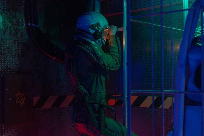 a man in a space suit talking on a cell phone, cyberpunk art, inspired by Elsa Bleda, pexels contest winner, holography, sitting in a dark prison cell, military pilot clothing, profile image, wearing human air force jumpsuit