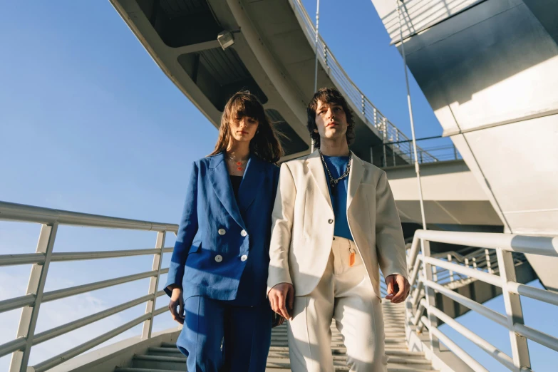 a man and a woman walking down a flight of stairs, an album cover, unsplash, bauhaus, blue suit, off - white collection, thumbnail, fashion shoot