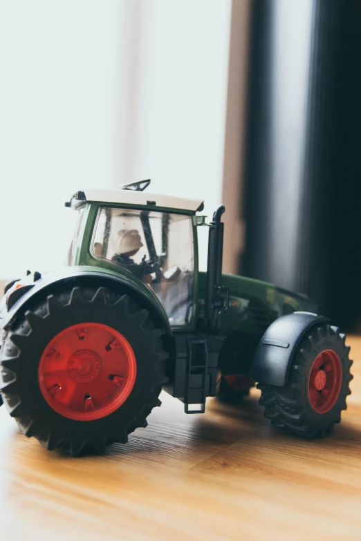 a toy tractor sitting on top of a wooden floor, by Andries Stock, pexels contest winner, figuration libre, tall farmer, 15081959 21121991 01012000 4k, talking, canvas