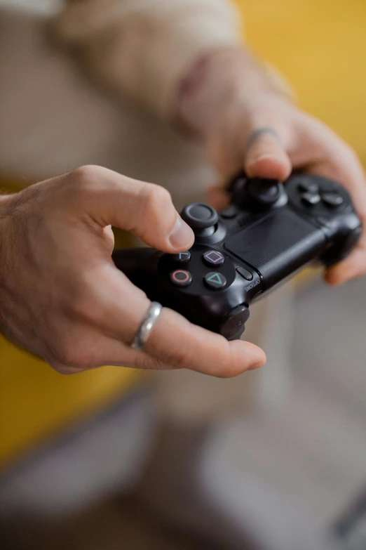 a close up of a person holding a video game controller, square, playstation 4, journalism photo, f/1.4