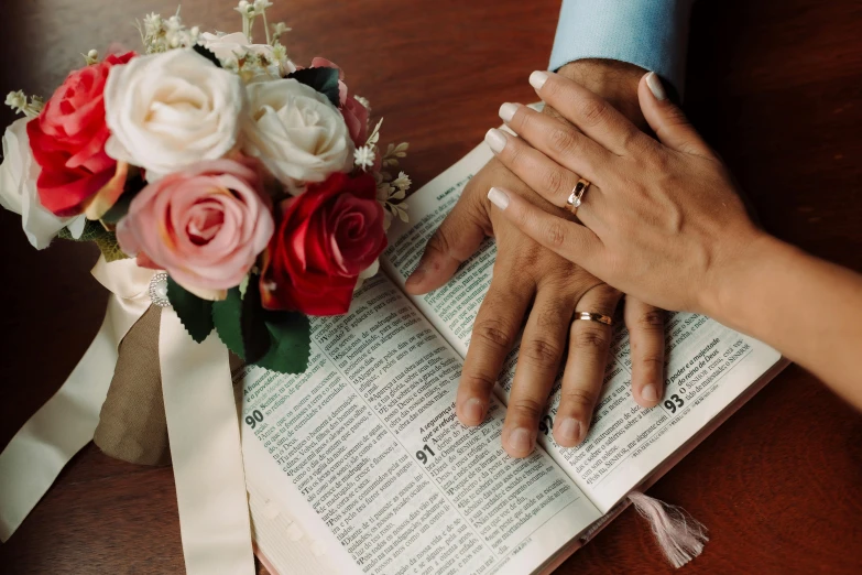 a man and a woman holding hands over an open book, an album cover, by Julia Pishtar, pexels, bouquet, religious, 15081959 21121991 01012000 4k, thumbnail