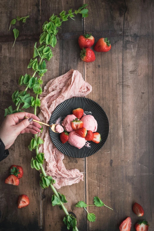 a black plate topped with strawberries on top of a wooden table, a picture, pexels contest winner, renaissance, eating ice cream, minimal pink palette, organic, mix