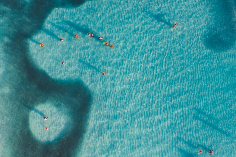 a group of people floating on top of a body of water, turquoise water, hyperdetailed photo, manly, shade