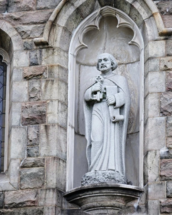 a statue that is on the side of a building, inspired by Thomas Aquinas Daly, unsplash, romanesque, gray men, marilyn church h, upon a peak in darien, entrance