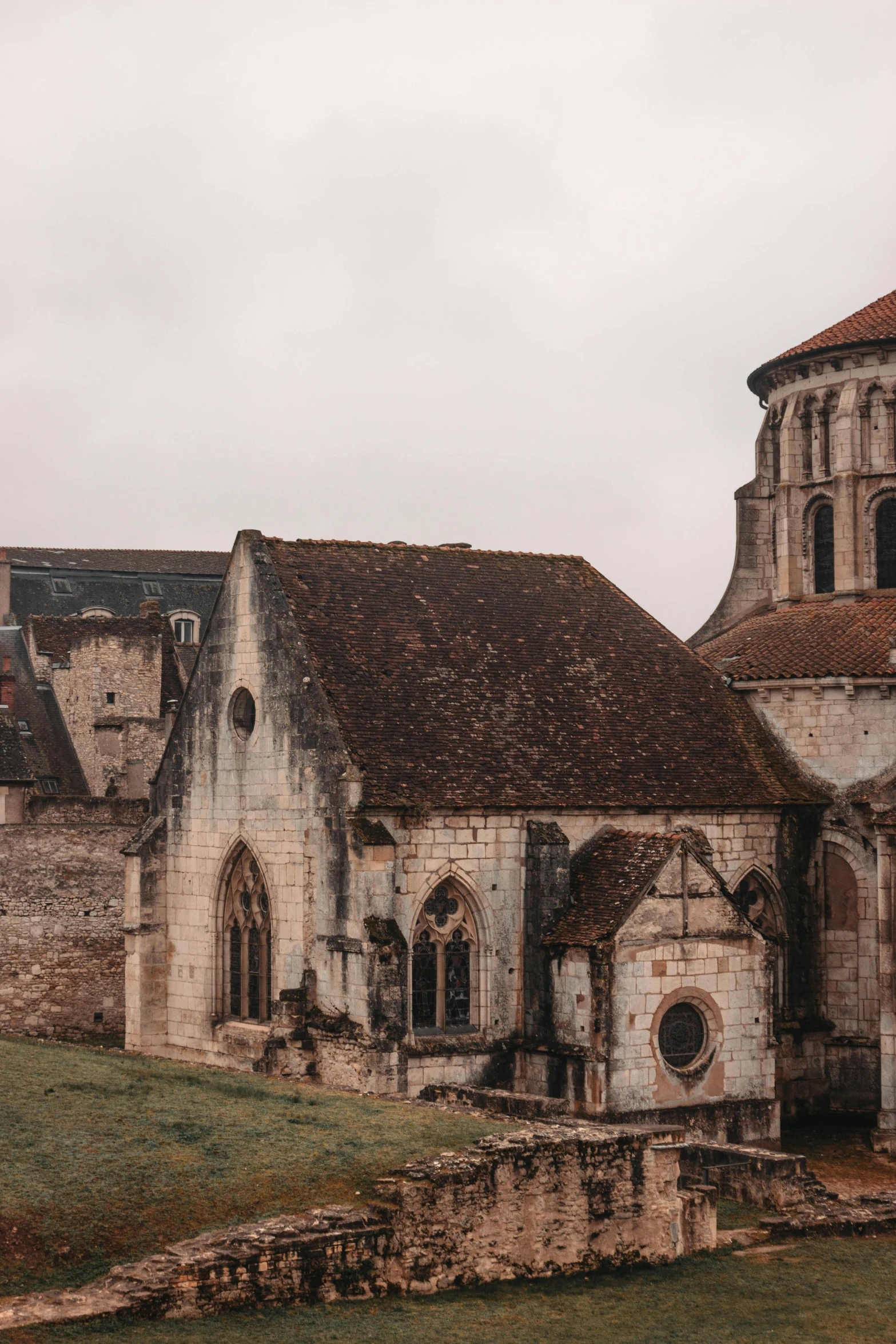 a large stone building sitting on top of a lush green field, an album cover, pexels contest winner, romanesque, french village exterior, panoramic, destroyed church, red roofs